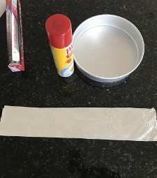 prepping the elmo cake materials with a pan, PAM spray, and tinfoil