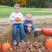 boys on a fall scavenger hunt holding pumpkins
