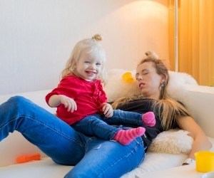 exhausted mom of toddler sleeping after childproofing