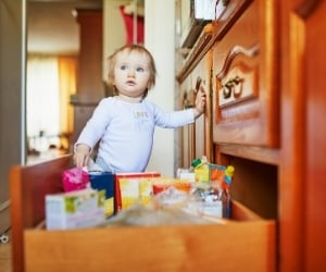 toddler next to cabinet drawers not childproofes