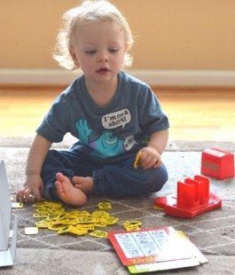 2 or 3 year old boy playing a Zingo board game