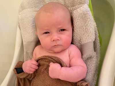a one month old baby in the bath tub