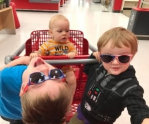 toddler preschooler and baby in a shopping cart