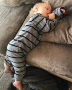 toddler asleep on couch because napping is an important daily toddler activity 
