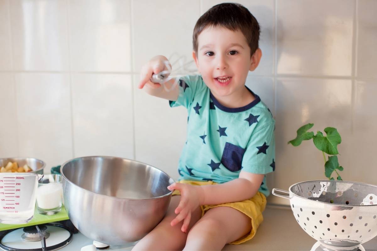 picture of a boy kid using kitchen items as toys